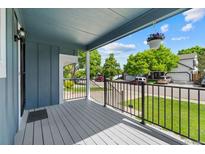Inviting front porch with black railing and hanging flower basket offers a relaxing outdoor space at 9816 Garwood St, Littleton, CO 80125