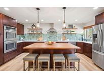 Stunning kitchen with a large island, stainless steel appliances, and custom backsplash at 4165 Ingalls St, Wheat Ridge, CO 80033