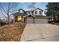 Charming two-story home featuring a brick facade, three-car garage, and a well-manicured front yard at 10039 Heatherwood Pl, Highlands Ranch, CO 80126