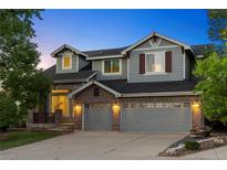 Charming two-story home with a brick facade, two-car garage, and manicured front yard at 10039 Heatherwood Pl, Highlands Ranch, CO 80126