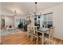 Bright dining room features a modern chandelier, hardwood floors and an open floor plan at 8543 Redstone St, Highlands Ranch, CO 80126