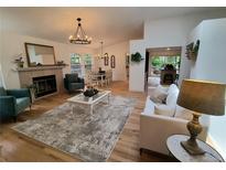 Bright living room features an open floor plan, hardwood floors, and a cozy fireplace at 8543 Redstone St, Highlands Ranch, CO 80126