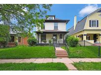 Charming two-story home featuring a welcoming front porch and well-maintained lawn at 2411 N High St, Denver, CO 80205