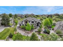 Beautiful two-story stucco home with stone accents, lush landscaping, and a paved driveway on a sunny day at 5428 Forest View Rd, Parker, CO 80134