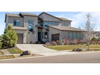 Beautiful home featuring a stone and siding exterior, professional landscaping, and a large driveway leading to an attached garage at 8172 S Langdale Way, Aurora, CO 80016