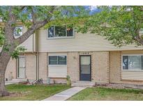 Attractive exterior of a light brick townhouse with well-maintained landscaping at 1282 S Troy St, Aurora, CO 80012