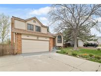Charming two-story home featuring a well-maintained lawn, mature trees, and attached two-car garage, located at 9911 at 9911 Perry Ct, Westminster, CO 80031