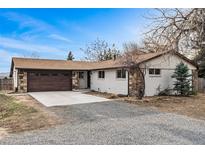 Charming brick and siding home featuring an attached two-car garage and manicured landscaping at 14290 W 54Th Ave, Arvada, CO 80002