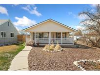 Charming home featuring a covered front porch, well maintained yard and beautiful curb appeal at 2019 S Fox St, Denver, CO 80223