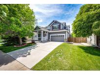 Charming two-story home featuring a well-manicured lawn, mature trees, and a spacious two-car garage at 5794 S Yakima Way, Aurora, CO 80015