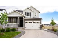Charming two-story home featuring a covered porch, manicured lawn, and a two-car garage at 27655 E Geddes Pl, Aurora, CO 80016