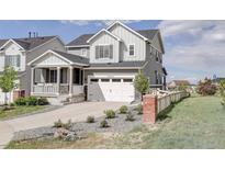 Charming two-story home with a two car garage, inviting porch, and beautifully landscaped front yard at 27655 E Geddes Pl, Aurora, CO 80016