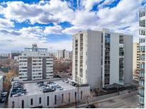 An exterior view of a high rise condominium featuring a rooftop parking structure on a clear day at 777 N Washington St # 204, Denver, CO 80203