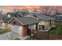 Charming home with a two-car garage, brick accents, and colorful decorations at 464 Chiswick Cir, Highlands Ranch, CO 80126