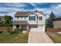 Charming two-story home featuring a two car garage, well-kept lawn, and stylish blue shutters at 9719 Burberry Way, Highlands Ranch, CO 80129