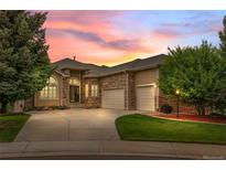 Charming home featuring a stone facade, manicured lawn, and three-car garage at 1251 Double Eagle Ct, Castle Rock, CO 80104