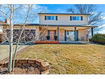Charming two-story home with a brick facade, covered porch, and well-maintained front yard at 7258 Braun Way, Arvada, CO 80005