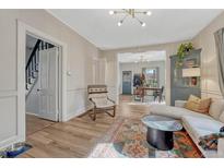 Inviting living room featuring hardwood floors, neutral paint, and an open floor plan to the dining room at 2819 W 43Rd Ave, Denver, CO 80211