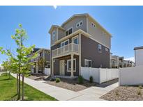 Two-story home with gray and beige siding, white trim, and small balcony over front door at 5121 N Yampa St, Denver, CO 80249