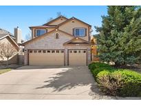 Charming two-story home with a well-manicured lawn and an attached two-car garage at 12710 W 84Th Cir, Arvada, CO 80005