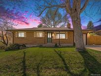 Charming brick home featuring a well-manicured front yard and mature shade tree at 1475 S Urban Way, Lakewood, CO 80228