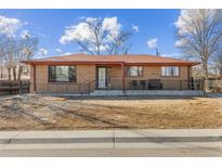 Charming brick home with a well-kept front yard and inviting front porch, creating a warm and welcoming curb appeal at 1275 Otis St, Lakewood, CO 80214