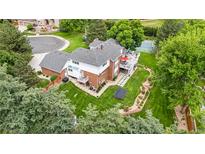 Expansive backyard featuring patio, deck, trampoline, and landscaped garden beds at 7330 Routt St, Arvada, CO 80005