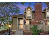 Charming two-story home boasts a brick chimney and cozy string lights enhancing the entryway's appeal at 1907 S Helena St # G, Aurora, CO 80013