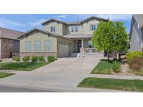 Charming two-story home with an attached garage, manicured lawn, and a welcoming front porch at 525 Grenville Cir, Erie, CO 80516