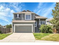 Charming two-story home with well-maintained landscaping, a two-car garage, and a welcoming front porch at 8935 Sleepy Grass Ct, Parker, CO 80134