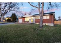 Charming brick home with a well-maintained front yard and attached garage features inviting curb appeal at 2878 S Patton Ct, Denver, CO 80236