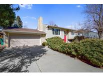 Charming two-story home featuring a red front door and a well-maintained front yard with mature bushes at 14453 W 3Rd Ave, Golden, CO 80401