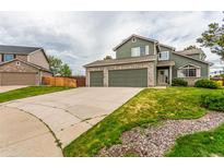 Two-story home boasts a three-car garage, green siding and a stone-accented facade, all under a cloudy sky at 21396 E Prentice Ln, Centennial, CO 80015