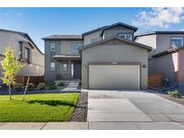 Two-story home with gray siding, attached two-car garage, and a well-maintained front lawn at 13398 E 99Th Pl, Commerce City, CO 80022