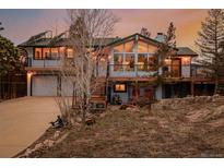 Stunning exterior view of a two-story home with a large deck and mountain views at sunset at 37 High View Ln, Boulder, CO 80302
