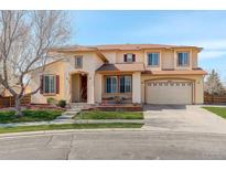 Charming two-story home with manicured lawn, arched entrance, and a two car attached garage at 16650 E 107Th Ct, Commerce City, CO 80022