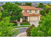 Charming two-story home featuring a well-manicured lawn and a welcoming two-car garage at 16650 E 107Th Ct, Commerce City, CO 80022