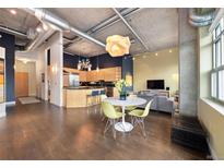 Open-concept living space with a modern kitchen, dining area, and stylish decor with exposed ductwork and concrete ceilings at 1890 Wynkoop St # 806, Denver, CO 80202