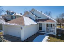 Charming two-story home with a covered front porch, attached garage, and well-maintained landscaping in a suburban neighborhood at 21714 Silver Meadow Ln, Parker, CO 80138