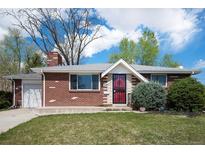 Charming brick home with a well-manicured lawn and inviting front entrance, featuring a red storm door at 8209 Benton Way, Arvada, CO 80003