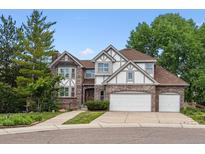 Charming two-story home with brick and neutral trim and a three-car garage at 9117 Buck Hill Dr, Highlands Ranch, CO 80126
