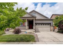 Charming two-story home with a well-maintained lawn, a two car garage, and a cozy front porch at 9643 Birch Ln, Thornton, CO 80229