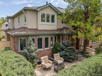 Charming home exterior with a private brick patio, comfortable seating, and manicured landscaping at 344 Saint Paul St, Denver, CO 80206