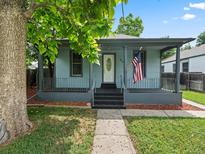 Charming single-story home featuring a welcoming front porch, American flag, and fresh landscaping at 4232 S Grant St, Englewood, CO 80113