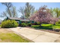 Charming one-story home with mature trees, lovely landscaping, and a cracked cement driveway at 1542 Kilkenny, Boulder, CO 80303