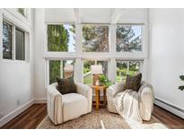 Bright sunroom with two comfy armchairs and plenty of natural light at 8387 S Reed St # B3, Littleton, CO 80128