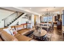 Bright, open-concept living space with hardwood floors, modern lighting, and staircase to upper level at 3361 Mariposa St, Denver, CO 80211