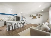 Open concept kitchen and living area with island and stainless steel appliances at 8070 Iris St, Arvada, CO 80005