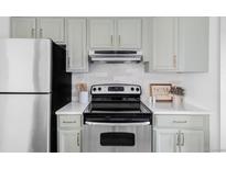 Updated kitchen features stainless steel appliances, quartz countertops, and light blue cabinets at 8787 Yukon St, Arvada, CO 80005