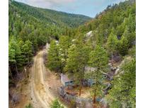 Charming two-story home tucked away in a serene, wooded area with a winding dirt road at 1608 Beaver Brook Canyon Rd, Evergreen, CO 80439